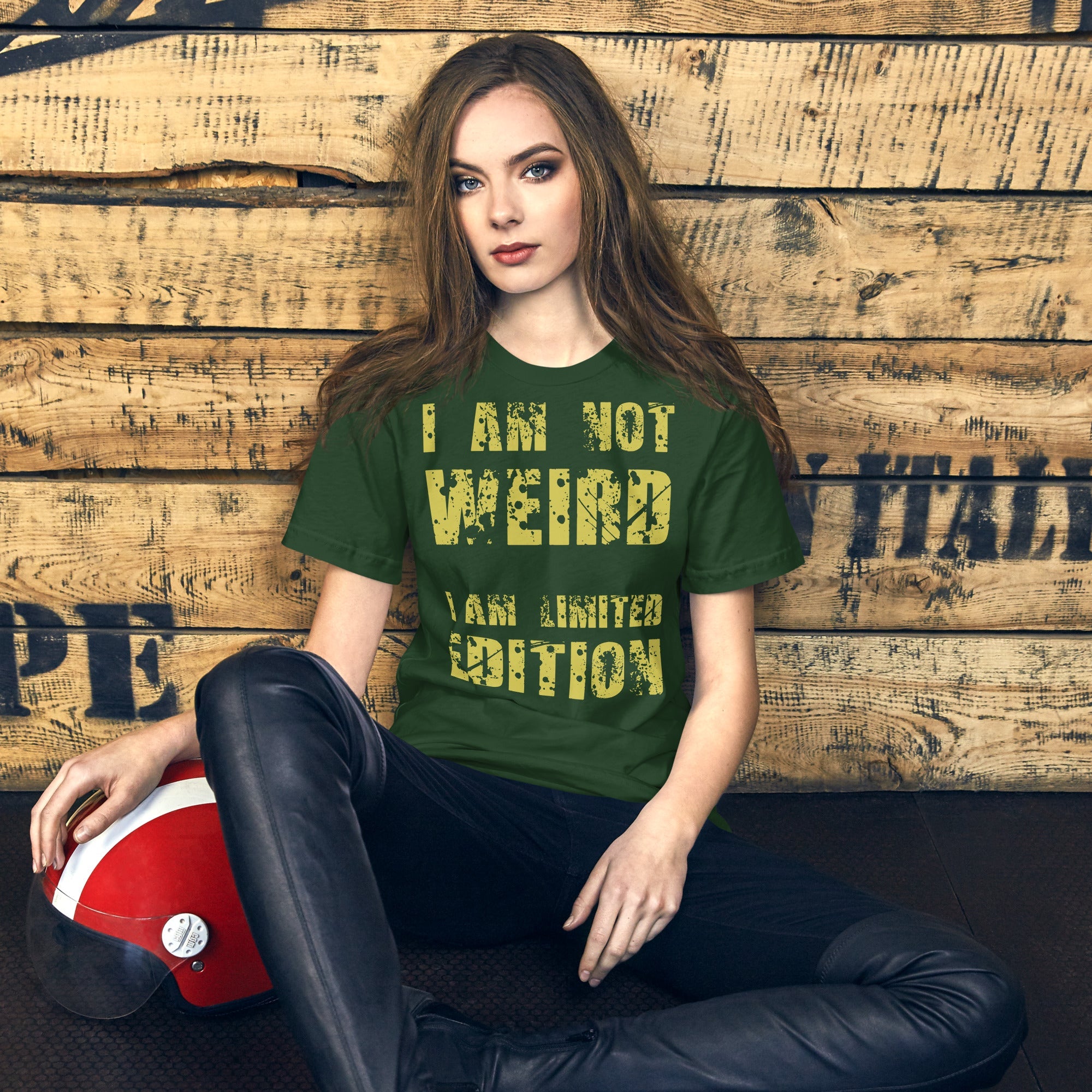 Unisex t-shirt with "I Am Not Weird" in yellow text, worn by a seated person in leather pants.
