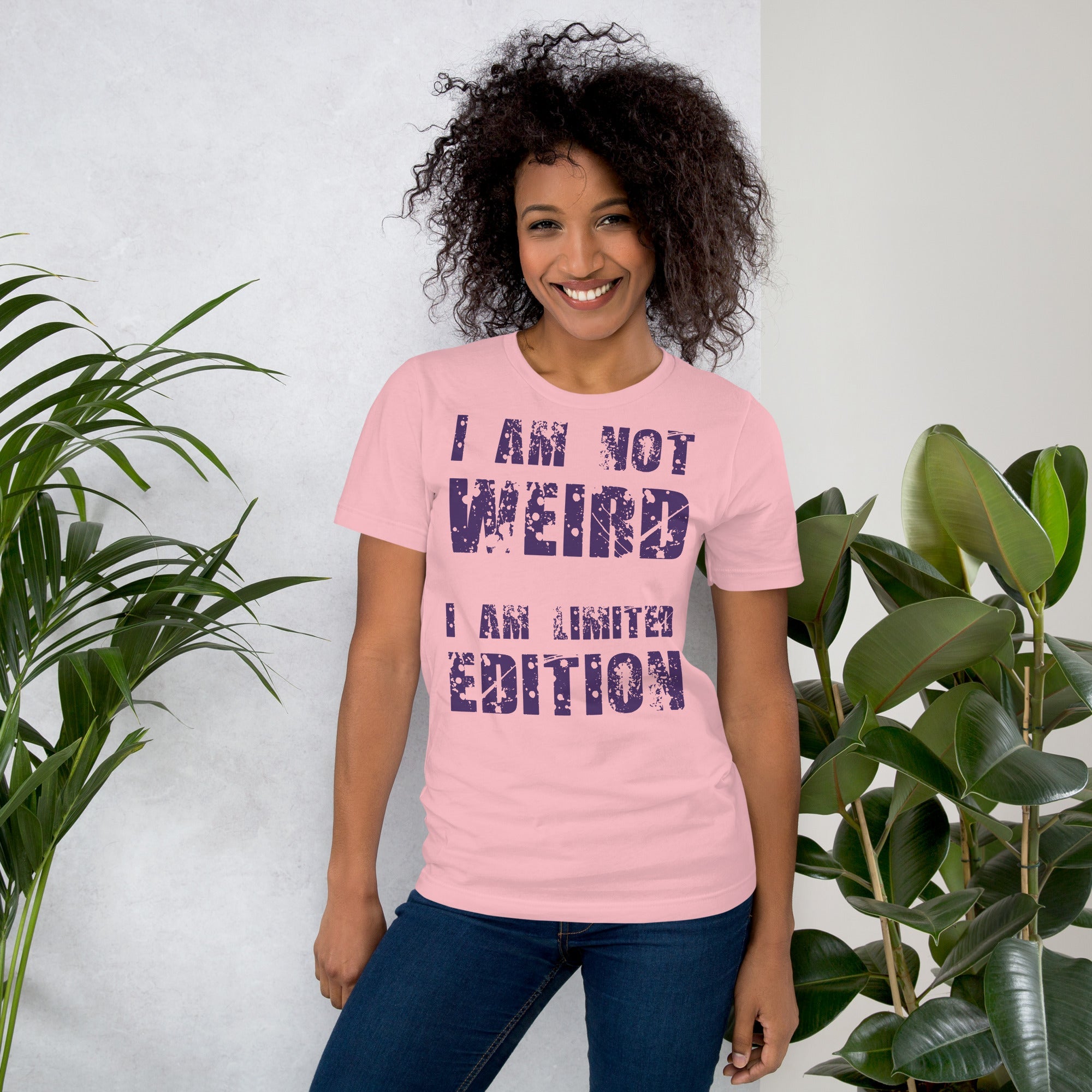 Unisex t-shirt with "I am not Weird" in purple text, worn by a smiling individual.