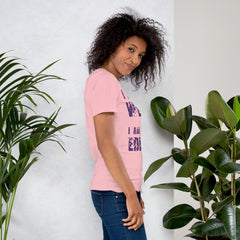 Unisex t-shirt with "I am not Weird" purple text design, shown in pink color, worn by a person standing near plants.