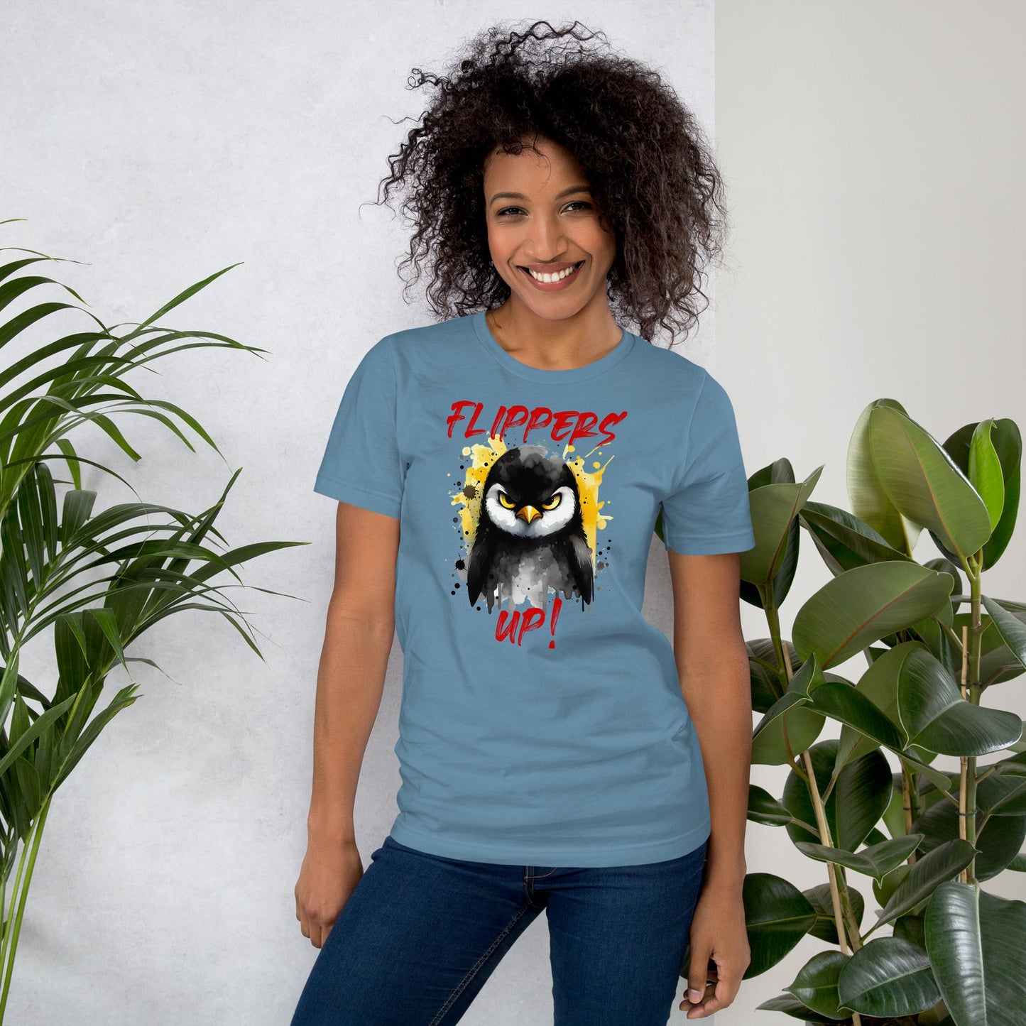 Unisex t-shirt with "Flippers Up" graphic, comfortable fit, displayed by a person standing near plants.