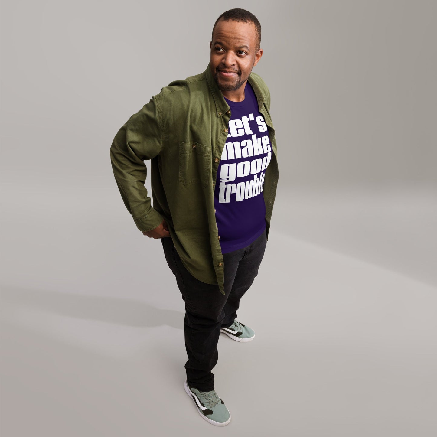 Man wearing a "Good Trouble" unisex t-shirt with text print, casual outfit.