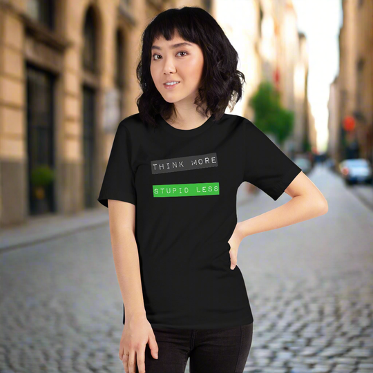 Unisex black t-shirt with "Think More, Stupid Less" graphic text, worn by a person on a city street.