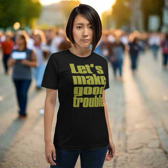 Unisex t-shirt with "Let's make good trouble" quote, worn by a person in a crowd.