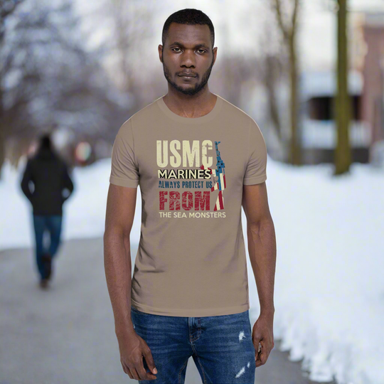 Marines-themed unisex t-shirt with "USMC Always Protect Us from the Sea Monsters" design, worn by a model outdoors in winter.