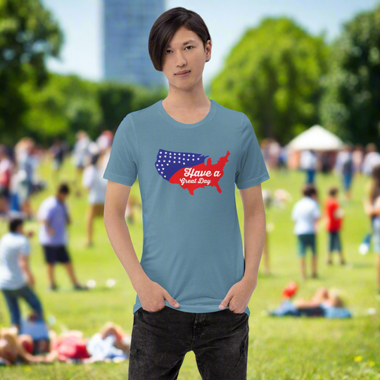 Unisex t-shirt with "Have a great day" text and map design, worn by a person in a park setting.