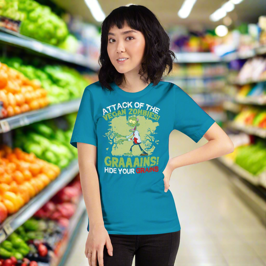 Unisex t-shirt with "Attack of the Vegan Zombies" cartoon design; quirky vegan-themed apparel.