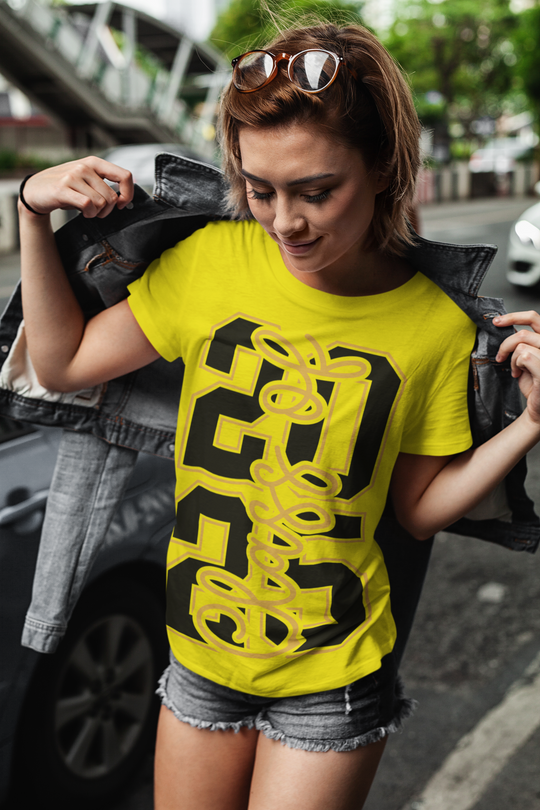 Class of 2025 vertical unisex t-shirt in yellow being worn by person outdoors.