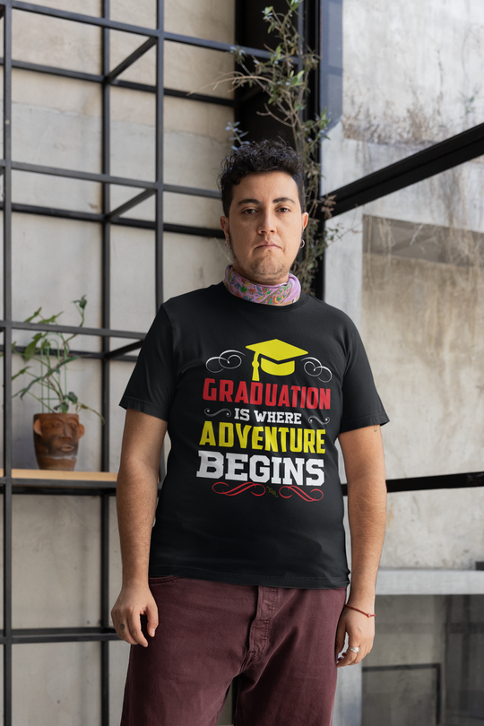 Unisex t-shirt with "Graduation is where adventure begins" design, worn by a person standing indoors.