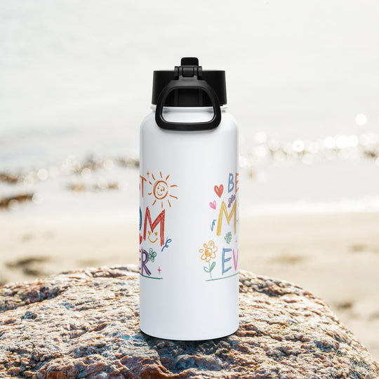 Best Mom Ever stainless steel water bottle with straw lid on rocky beach background.