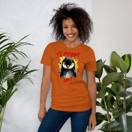 Unisex t-shirt with "Flippers Up" penguin design, soft and lightweight, worn by model, orange color.
