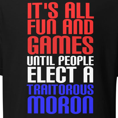 Unisex t-shirt with bold text "It's All Fun and Games Until People Elect a Traitorous Moron" in red, white, and blue.