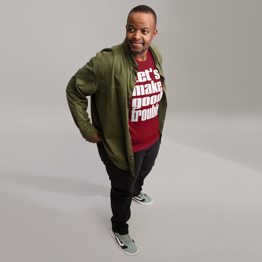 Unisex white t-shirt featuring "Let's make good trouble" quote, worn by a person standing confidently.
