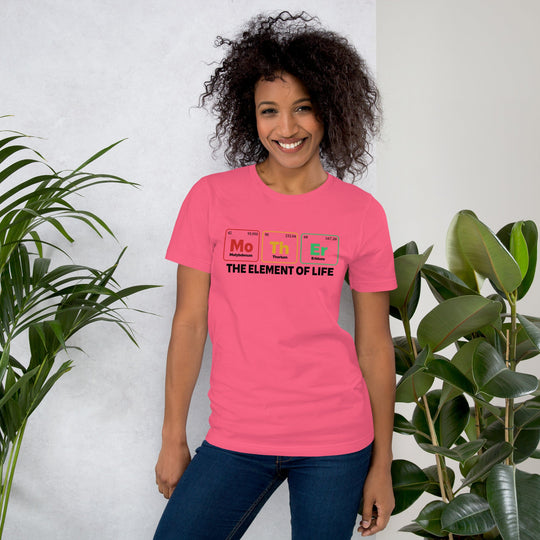 Light pink unisex t-shirt featuring "Mother - the Element of Life" periodic table design, worn by a smiling person indoors.