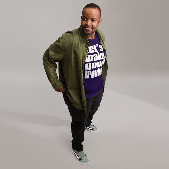 Man wearing a "Good Trouble" unisex t-shirt with text print, casual outfit.