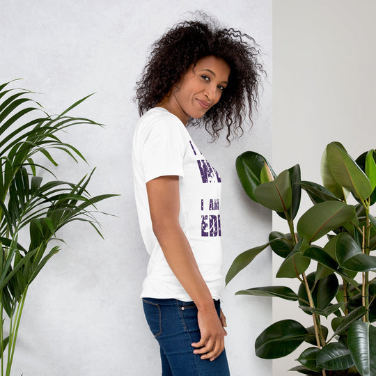 Woman wearing "I am not Weird" unisex t-shirt in purple text with plants in background.