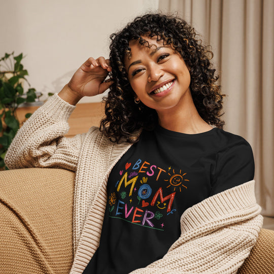 Best Mom Ever women's relaxed t-shirt in black featuring colorful design, worn by a smiling woman indoors.