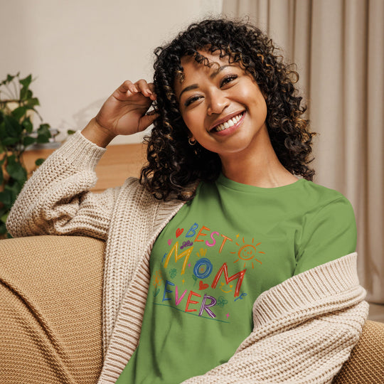 Woman wearing a "Best Mom Ever" relaxed green t-shirt with colorful lettering, paired with a cozy cardigan.