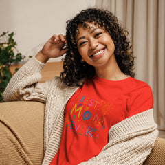 Smiling woman wearing "Best Mom Ever" red relaxed t-shirt with cardigan.